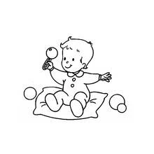 Coloriage Bébé jouant avec un hochet sur un coussin